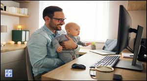 A man in his 30's, wearing black frame glasses, has his baby on his lap while working at his desk. They both look at the computer monitor and smile as the father recognizes that he has created a solid financial retirement plan for himself, and a reliable long-term financial plan for his son.